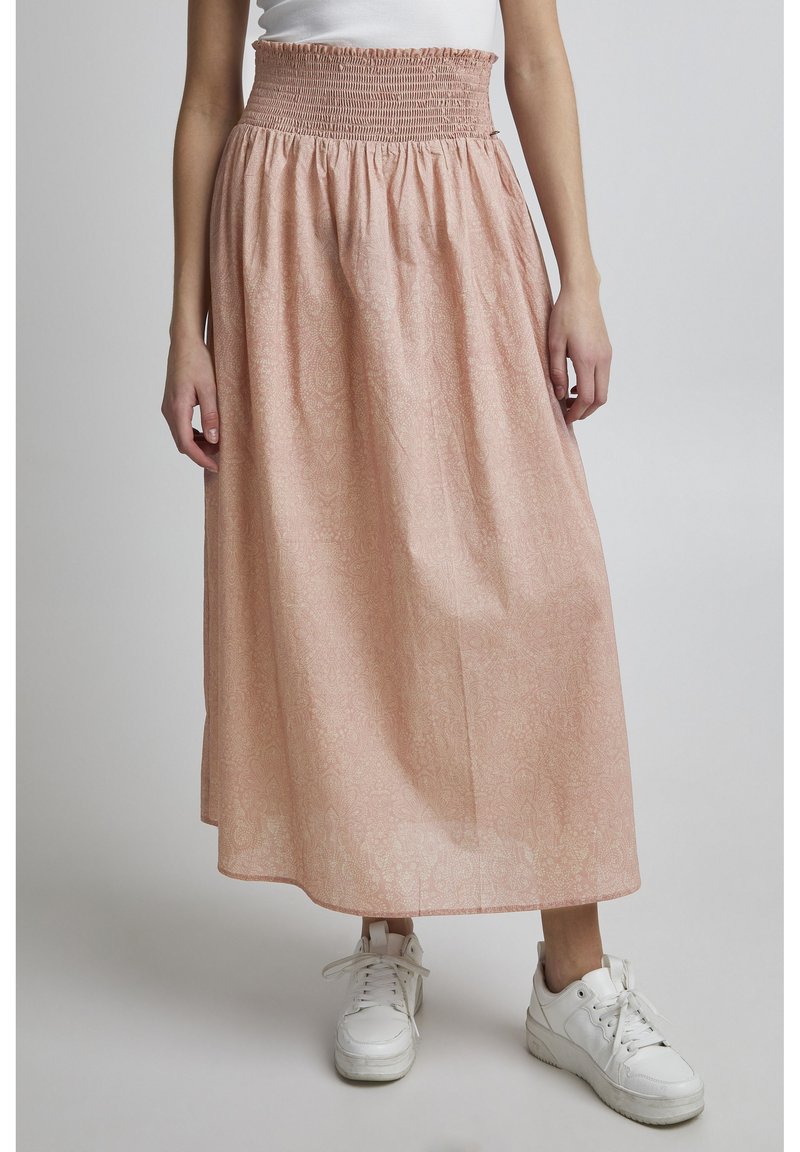 Gonna maxi rosa a fantasia con vita arricciata, caratterizzata da un tessuto morbido e un design fluido. Abbinata a sneaker bianche.