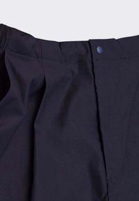Pantaloni blu navy con pieghe frontali, vita elasticizzata e chiusura con bottone. Tessuto liscio con una leggera lucentezza e senza motivi visibili.