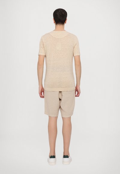 Hellbeige T-Shirt mit kurzen Ärmeln und passender Shorts aus weichem Stoff, mit lässiger Passform und minimalen Nähten.
