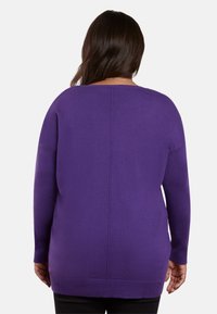 Lila oversized tröja med rund halsringning, långa ärmar och ribbade detaljer vid muddar och nederkant. Slät, mjuk textur.