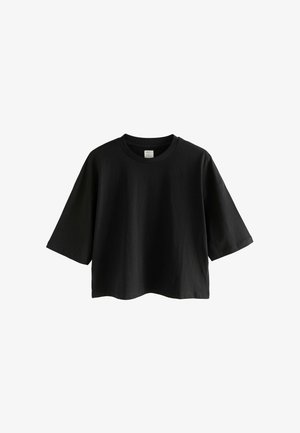 Fekete pamut póló, kerek nyakkal, rövid ujjú és laza fazonban. Sima felület, minimális dizájn minták vagy díszítések nélkül.