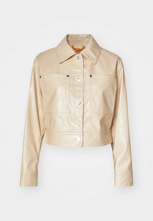 Cropped beige faux leather jacket with a point collar, silver snap buttons, two chest pockets, and smooth texture.