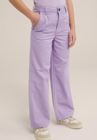 Levandulové široké kalhoty vyrobené z bavlny, se předními kapsami a klasickým pasem. S kombinací béžových a bílých tenisek.