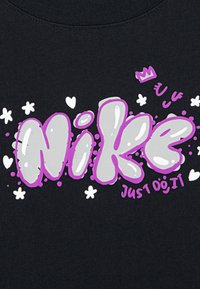 Μαύρη μπλούζα με μεγάλο λογότυπο "Nike" σε στυλ μπαλίτσας σε γκρι και μωβ, με τη φράση "Just Do It" σε λευκό χρώμα και διακοσμητικές καρδιές και αστέρια.