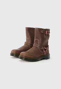 Brown leather boots with a round toe, pink buckle accents, and white stitching. Rubber soles with a textured pattern for grip.