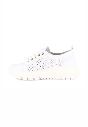 Sneaker bianca a basso profilo con lati traforati, occhielli dorati, suola spessa scanalata e linguetta al tallone, mostrata di profilo laterale.