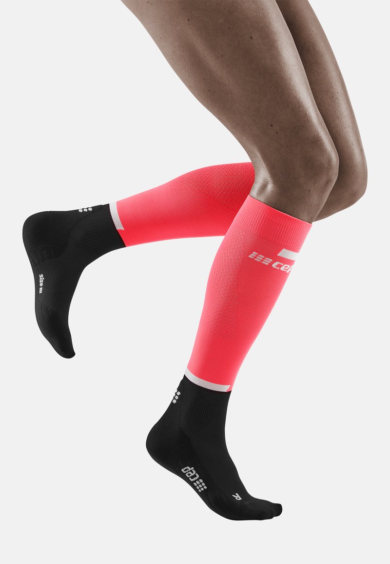 Calze a compressione alte fino al ginocchio con un vivace gradiente rosa, sezione del piede nera, accenti bianchi e tessuto testurizzato per una presa migliorata.