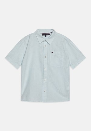 Chemise bleu clair à manches courtes avec tissu texturé, poche avant, col et petit logo Tommy Hilfiger sur la poche.