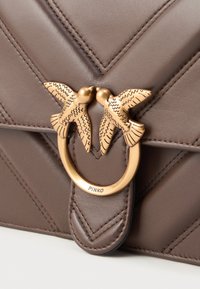 Bolsa de mão em couro castanho com padrão em ziguezague, apresentando um fecho em tom dourado em forma de duas aves a beijar e um detalhe de logotipo. Acabamento texturizado.