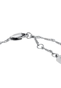 Bracelet en chaîne argentée avec des maillons en métal entrelacés, un fermoir sécurisé et un accent rectangulaire. Texture lisse avec une finition polie.