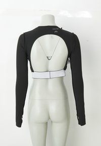 R�ückansicht eines schwarzen, langärmligen Cropped Tops mit großem, kreisförmigem Ausschnitt und weißem elastischem Band, präsentiert auf einer Schaufensterpuppe.