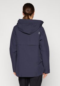 Granatowa wodoodporna kurtka z kapturem, posiadająca tylny karczek i subtelne logo. Gładka tkanina o lekko błyszczącej fakturze.