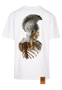 Hvit T-skjorte med en 3D-print av et marmor- og gullhodeskalle med ribbe- og ryggsøyledetaljer på baksiden, som viser et teksturert, kunstnerisk lagdelt design.