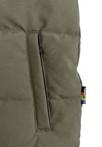 Olijfgroene geïsoleerde jack met een ritszak, gestructureerde stof en een multicolore "Thermo Tech" label aan de zijkant.