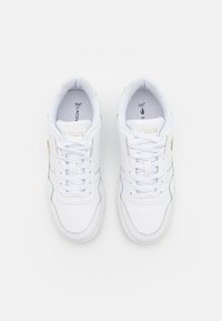 Białe skórzane sneakersy z teksturowanymi akcentami, płaskimi sznurowadłami, okrągłym noskiem i subtelnymi szarymi szwami. Złote logo marki po boku.