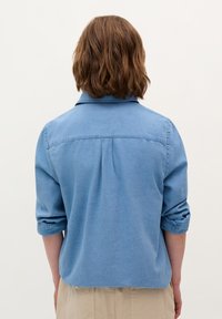 Blauwe denim shirt met een kraag, opgerolde mouwen en een achternaaddetail, met een gladde textuur in een relaxte pasvorm.