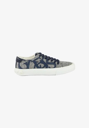 Lage sneaker met grijze stoffen bovenkant, marineblauwe letters en veters, en dikke witte rubberen zool met gestructureerde neuskap.