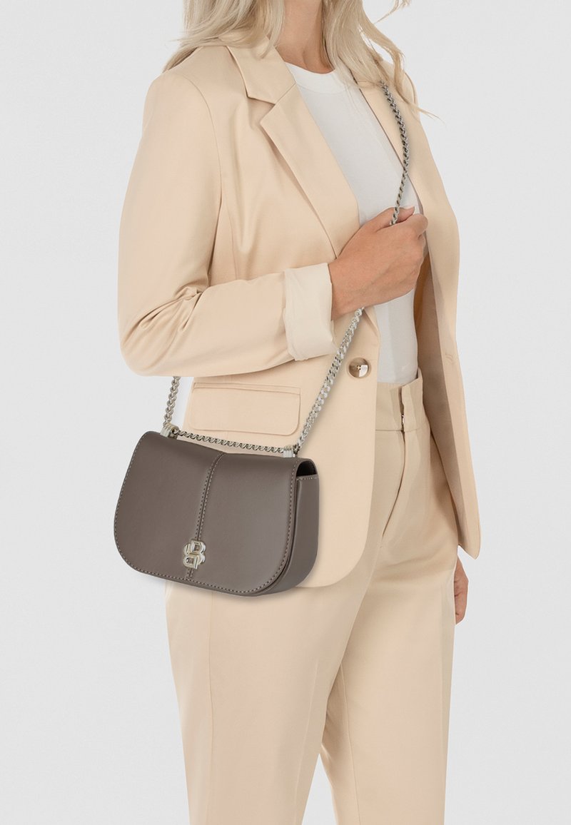 Borsa a spalla in pelle marrone con pattina curva, tracolla in catena argentata e dettaglio del logo, esposta su uno sfondo neutro.