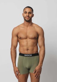 Grüne Boxer-Briefs mit einem schwarzen "SNOCKS"-Bund, aus glattem Stoff gefertigt, mit einem figurbetonten Design und ohne sichtbare Muster.