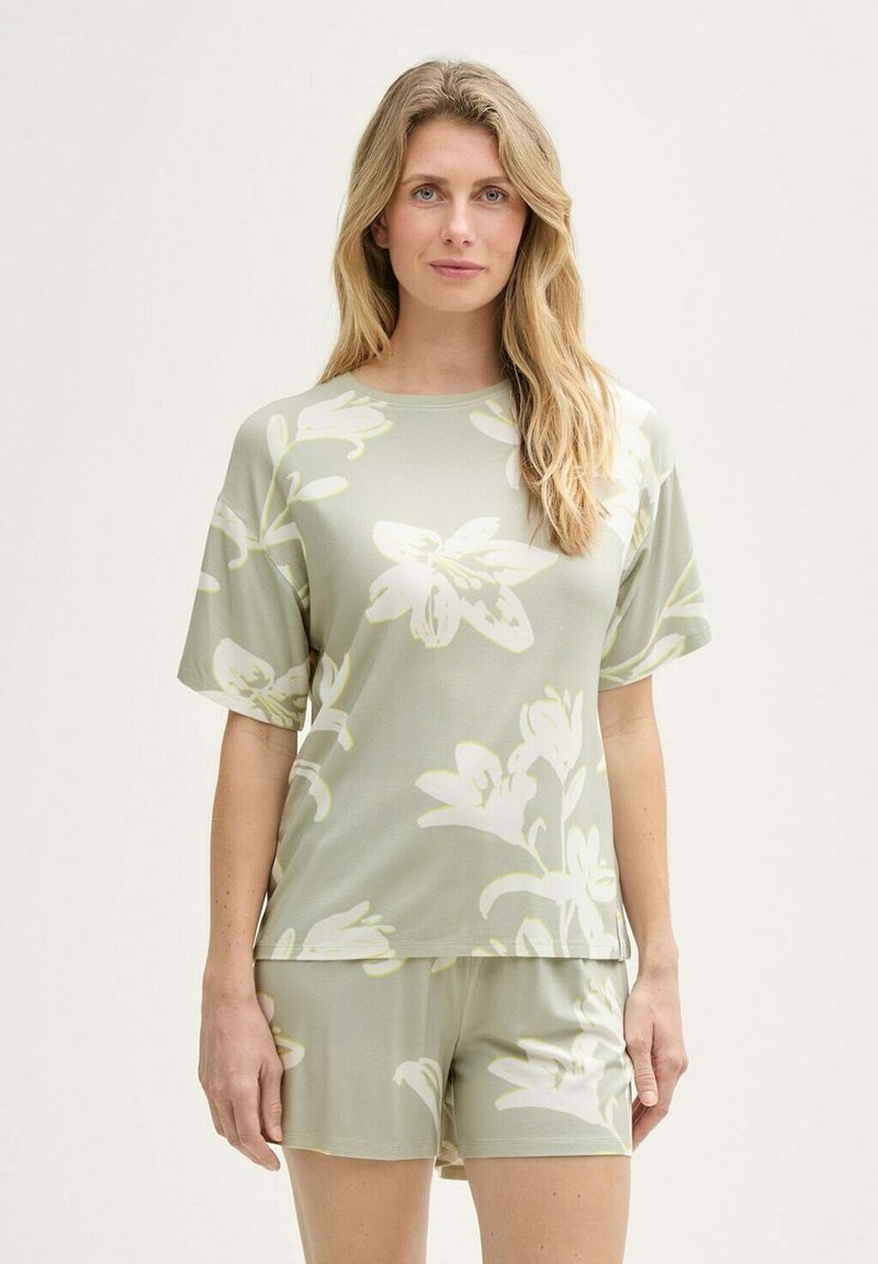 Conjunto de ropa de casa en suave tela verde con un gran patrón floral blanco. Parte de arriba de manga corta con corte relajado y pantalones cortos a juego, textura suave.