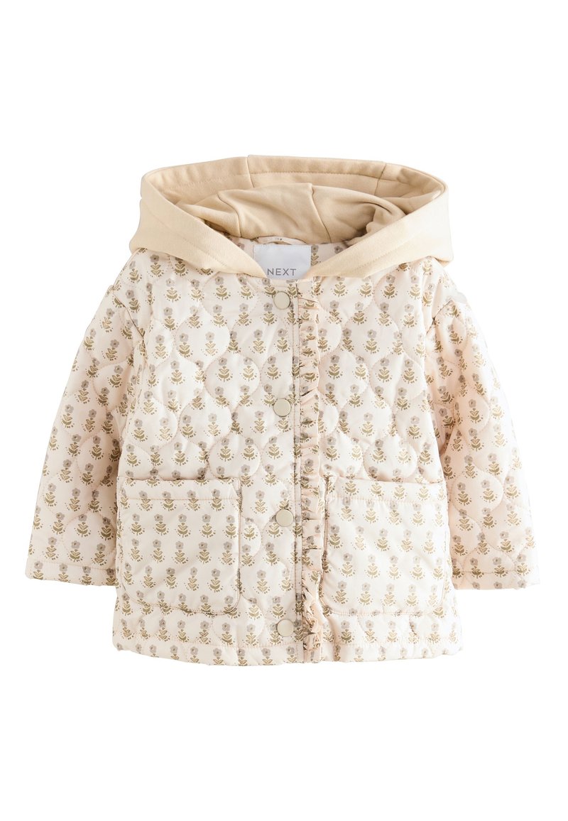 Veste matelassée crème avec capuche beige, ornée d'un motif floral, fermetures à pressions, et deux poches avant. Texture douce et détails en surpiqûres.