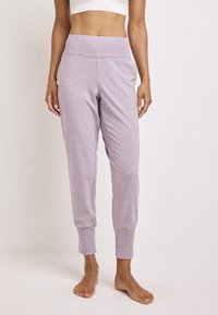 Lichtpaarse joggingsbroek van zachte stof, met een hoge tailleband en enkelboorden, een gladde textuur en zonder zichtbare patronen.
