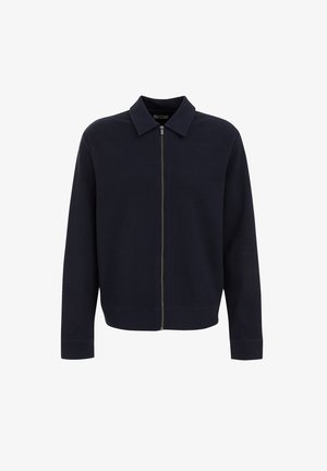 Veste zippée bleu marine avec col, fabriquée en tissu texturé. Présente des poignets et un ourlet côtelés, ainsi qu'une fermeture éclair centrale en métal.