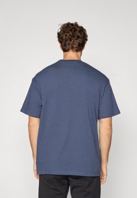 Kortsleeve navy blue t-skjorte med rund hals, med en glatt tekstur og avslappet passform, synlig søm langs kanten.