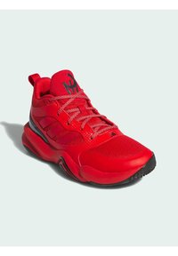 Roter Sportschuh mit einem strukturierten Netz-Obermaterial, schwarzen Akzenten und gemusterten Details. Verfügt über einen gepolsterten Kragen und eine Gummisohle für guten Halt.