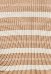 Žebrovo pletená látka s striedajúcimi sa pruhmi svetlo béžovej a bielej farby. Textúra je elastická a pohodlná s mäkkým povrchom.