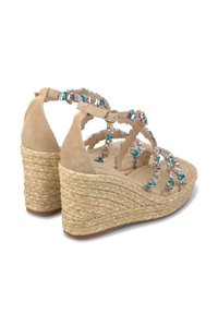 Beige suède wedge sandalen met geweven jute hakken, versierd met kleurrijke edelstenen langs de banden, met een verstelbare enkelgesp.