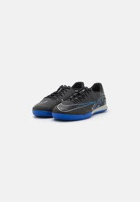 Zwarte sportschoenen met een textuur bovenkant, blauwe rubberen zool en zilveren accenten. Bevat standaard veters en een laag profiel ontwerp.