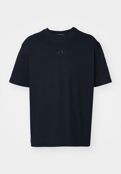 T-shirt preto de algodão com mangas curtas. Apresenta um logótipo minimalista em um tom mais escuro no peito. Design clássico de gola redonda.