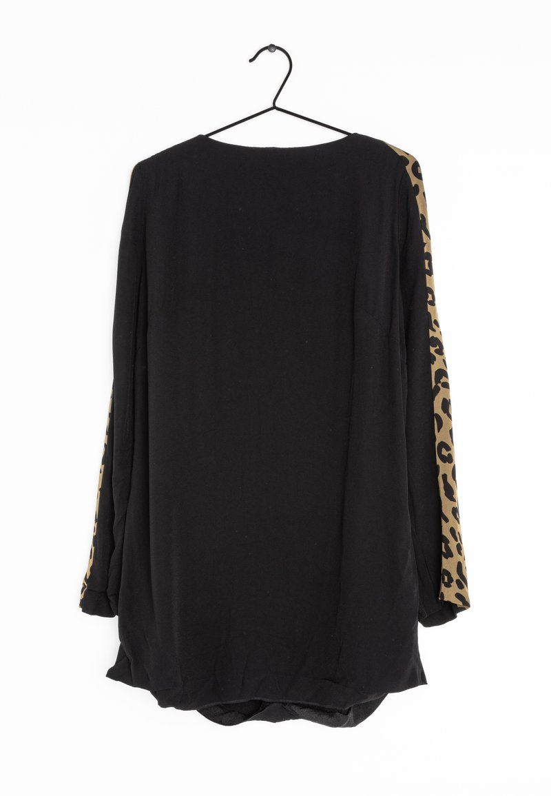 Chemise noire à manches longues sur un cintre avec des panneaux à motif léopard courant sur les côtés extérieurs des deux manches.