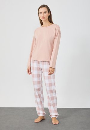 Maglia rosa chiaro a maniche lunghe abbinata a pantaloni del pigiama a quadretti rosa e bianchi. I pantaloni presentano polsini elastici e una vestibilità comoda. Tessuto morbido.