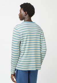Langslavige shirt in een crème en lichtblauwe gestreepte patroon, met een ronde halslijn en een losse pasvorm. Zachte textuur, eenvoudig ontwerp.