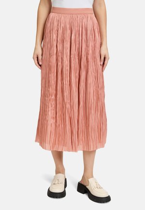 Plisseret midi nederdel i blød pink stof med en bred talje, der har en gennemsigtig struktur og flydende design. Sammen med beige loafers.