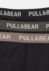 Set de trei perechi de chilot cu talie elastică contrastantă pentru bărbați. Culori: negru, verde și bej. Toate prezintă logo-ul "PULL&BEAR" în alb.