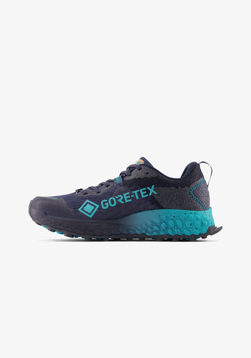 Trail running shoes in dark navy with turquoise accents. Made of mesh and synthetic materials, featuring a textured sole for grip.