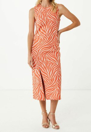 Ærmeløs orange og beige zebra-print midi kjole med frontslids, båret med guld højhælede sandaler på en stående kvinde.