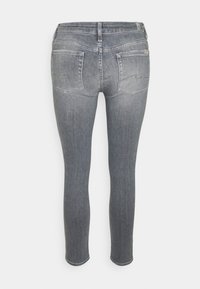 Jeans skinnies de mezclilla gris con cintura alta, que cuentan con dos bolsillos traseros y un ligero desgaste a lo largo de las piernas para un aspecto texturizado.