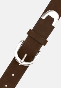 Brūns ādas josta ar sudraba metāla sprādzi. Aprīkota ar vairākiem caurumiem lieluma regulēšanai. Gluda tekstūra ar smalku zīmola detaļu.