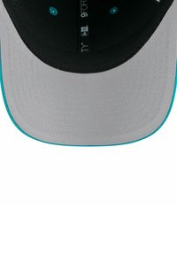 Cappellino da baseball grigio con visiera piatta, dotato di una parte interna nera e dettagli turchesi lungo la visiera e le aperture di ventilazione. Tessuto testurizzato.