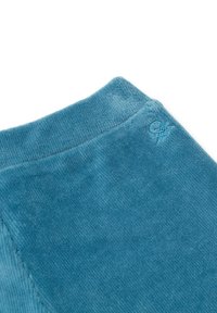 Tyrkysová kordurová látka s jemnou strukturou, na boku s nenápadnou výšivkou loga. Design má vroubkovaný vzor.