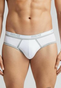 Weiße Baumwollslips mit einem grauen elastischen Bund. Mit dem Logo "Intimissimi uomo" am Bund und einer glatten Textur mit minimalen Nähten.