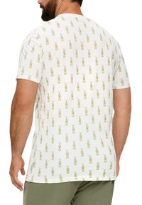 Korte mouw t-shirt in het wit, met een herhalend patroon van groene en roze ananas. Zachte stof met een losse pasvorm.