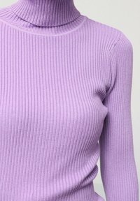 Pull à col roulé côtelé en violet clair, présentant une coupe ajustée et une texture lisse. Manches longues avec un col haut.