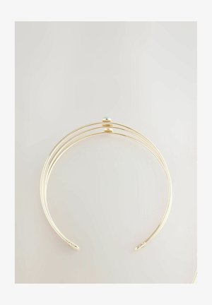 Guldtonet armbånd med tre buede bånd, der har en central teal sten accent på en glat overflade og åbne ender for justerbar pasform.
