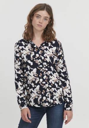 Langarmhemd in Marineblau mit einem weißen, braunen und orangen Blumenmuster. Verfügt über einen kragenförmigen Ausschnitt und Knöpfe auf der Vorderseite.