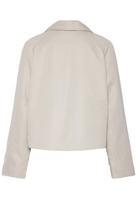 Giacca beige cropped con maniche lunghe e ampio collo, mostrata da dietro su uno sfondo bianco.